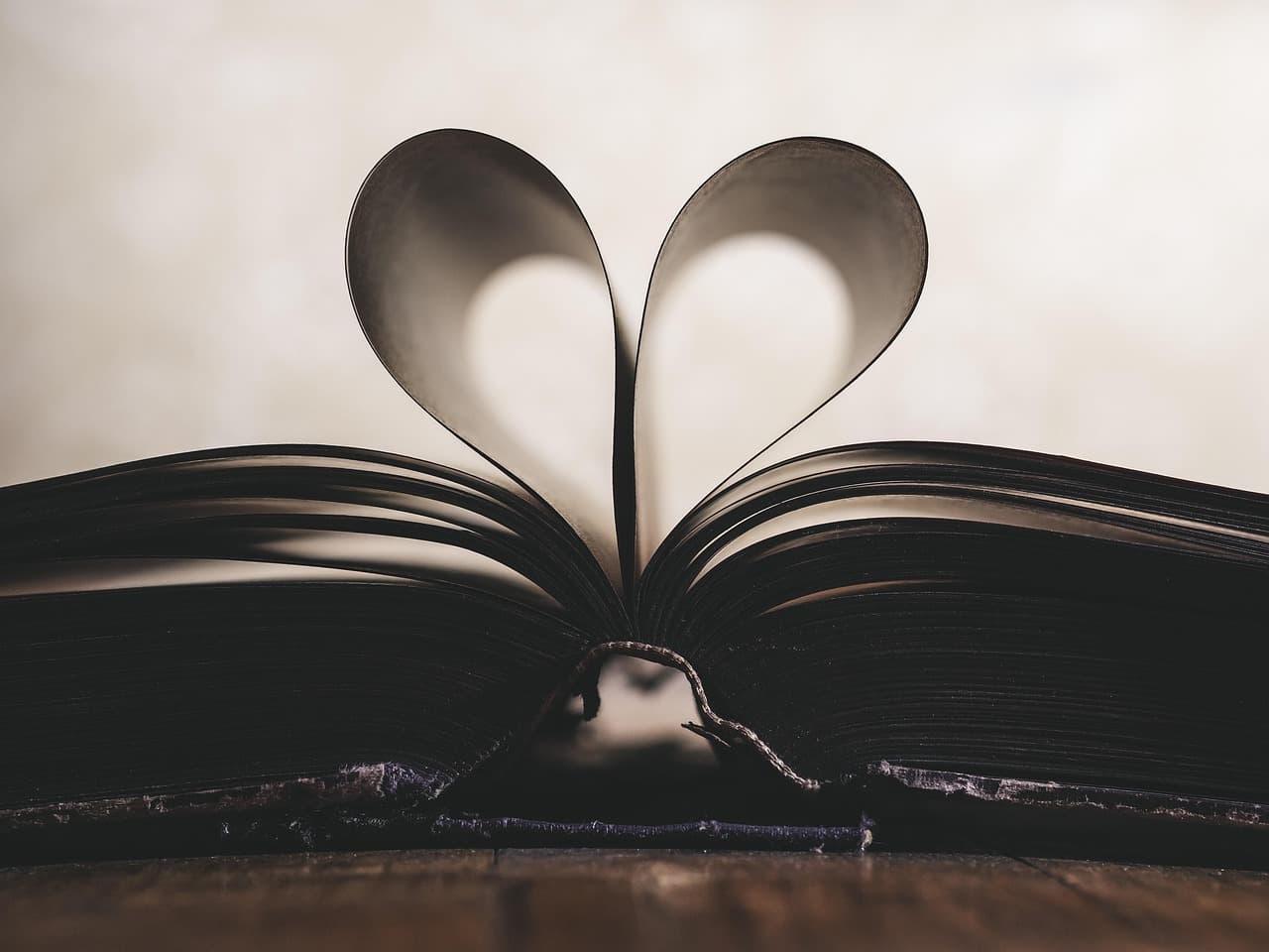 Open book with pages fanning out on a wooden table, representing beginner-friendly reading material