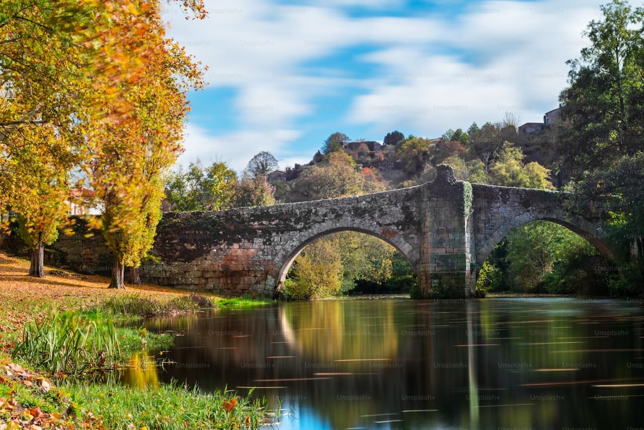 Stone bridge and medieval fortifications in a Castilian village, evoking the rural Spanish setting of Lope de Vega's Fuenteovejuna