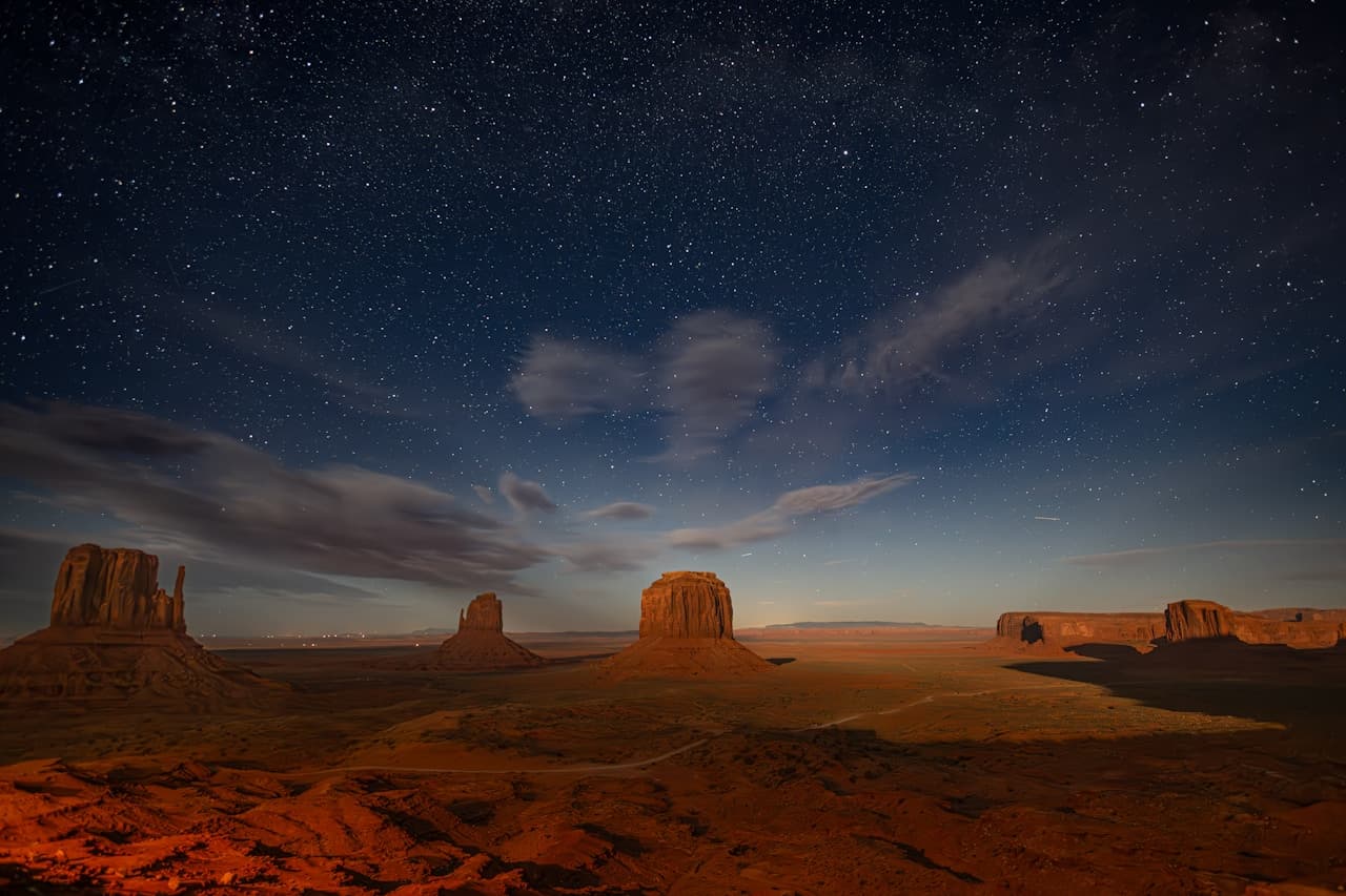 Starry night sky over desert sand dunes, evoking the world of The Little Prince