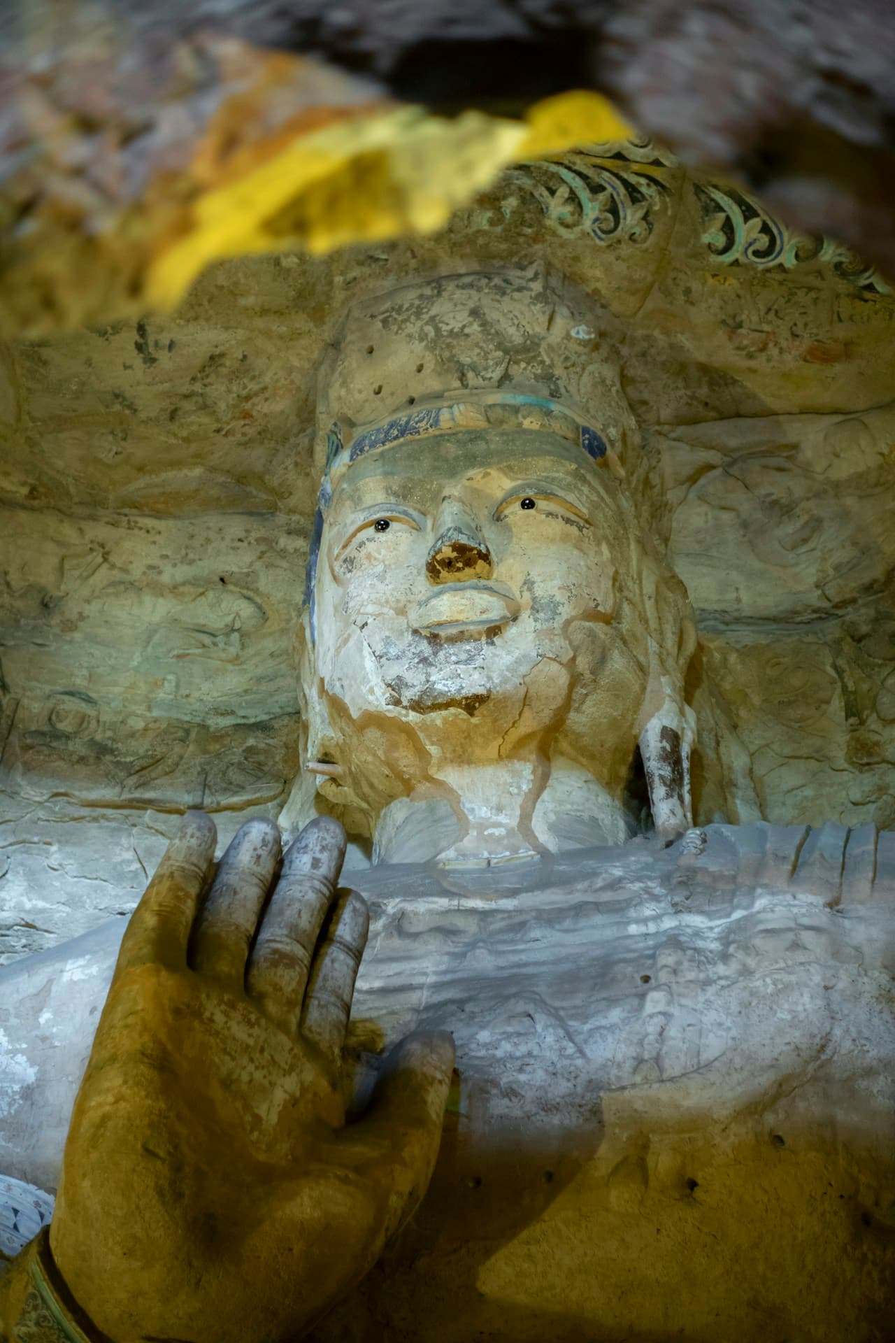Stone Buddha statue surrounded by soft golden light, evoking the spiritual journey of Siddhartha